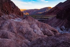 Sunset illuminates the colorful Painted Hills with vibrant reds and purples.