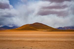Serene desert scene with rolling hills and dramatic clouds overhead. Perfect for travel and nature p.